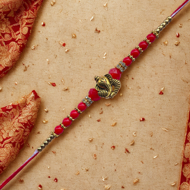 Ganesh Motif Rakhi with Red Beads & Golden Accents