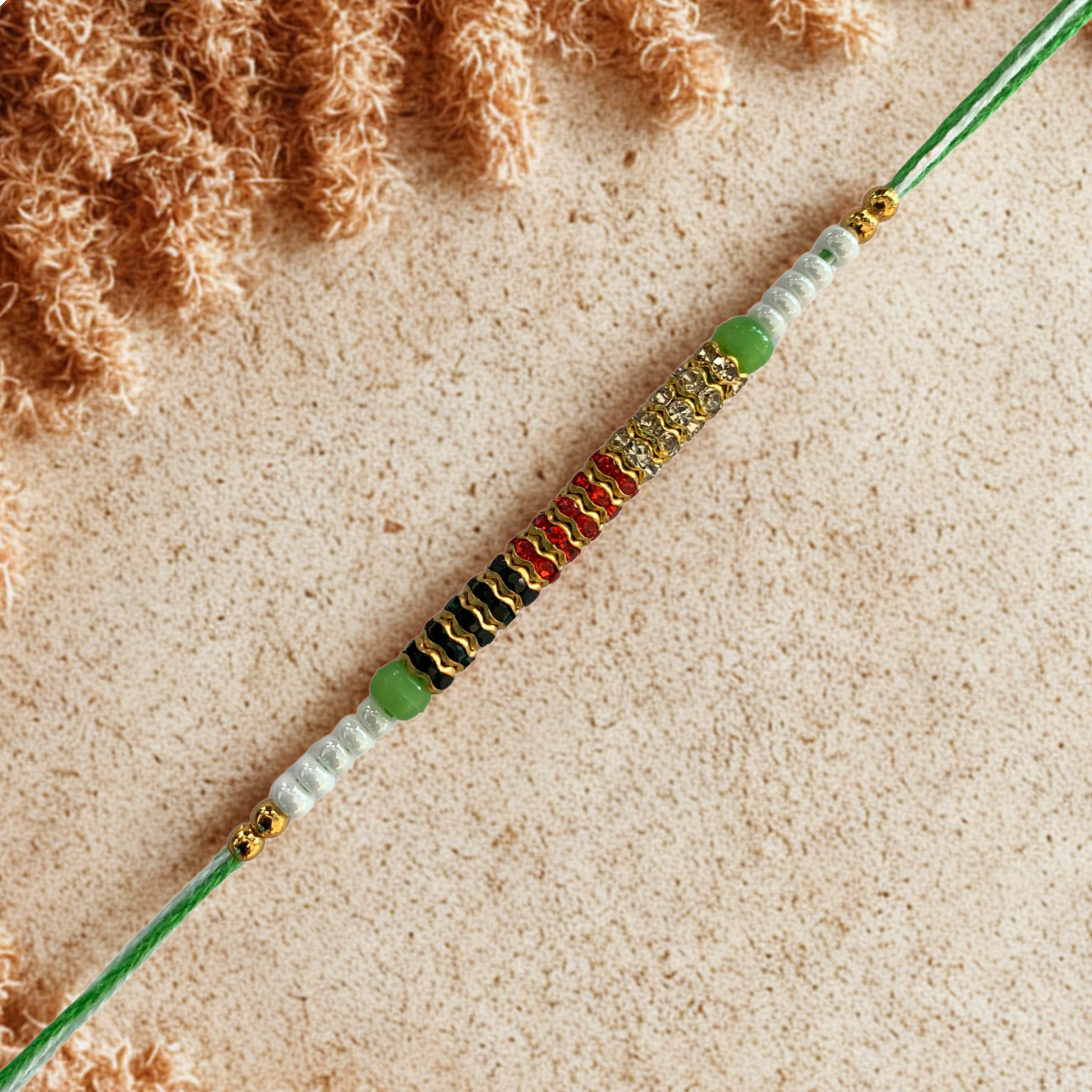 Multicolor Threaded Rakhi with Golden Rings and Green Thread
