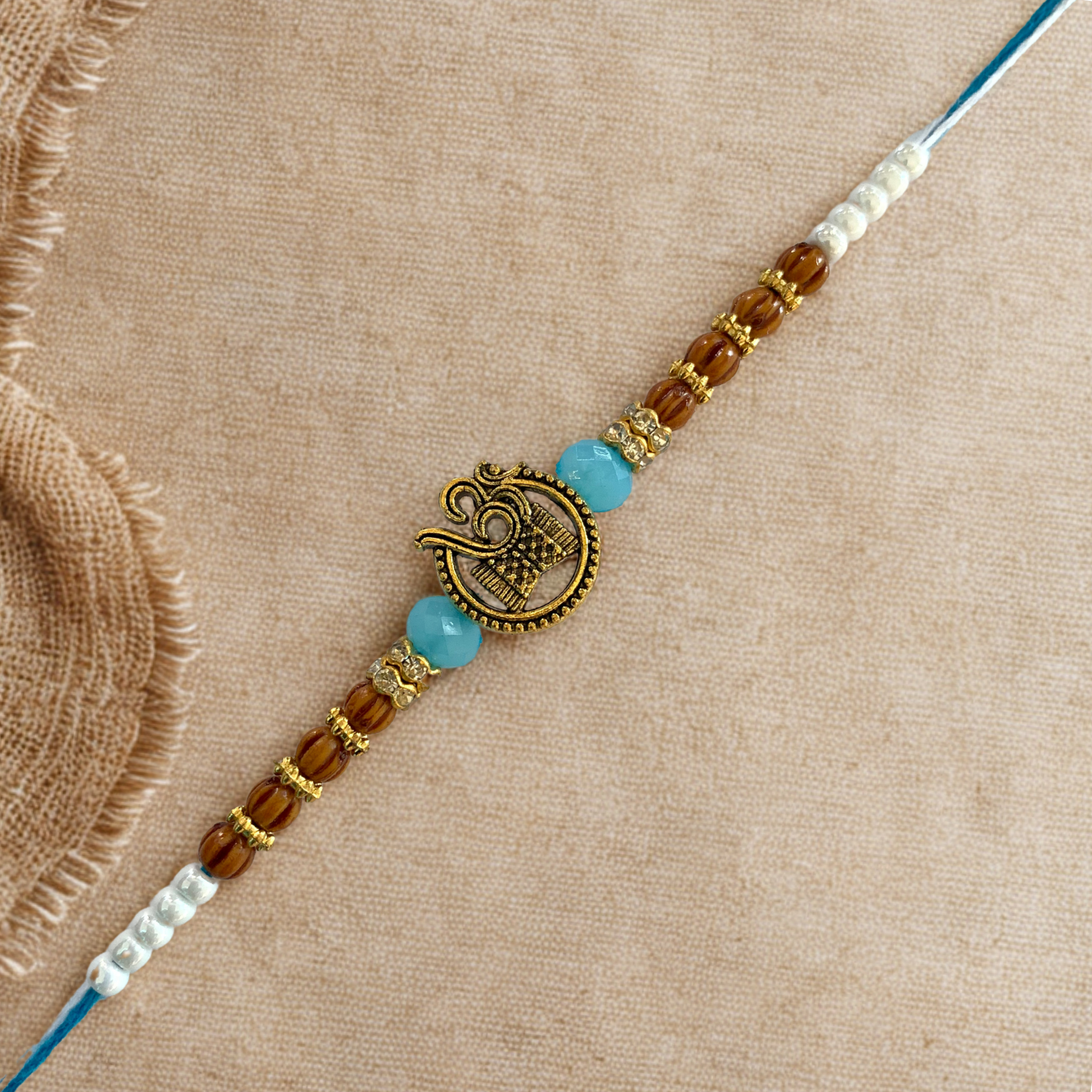 Spiritual Om Rakhi with Wooden & Light Blue Beads