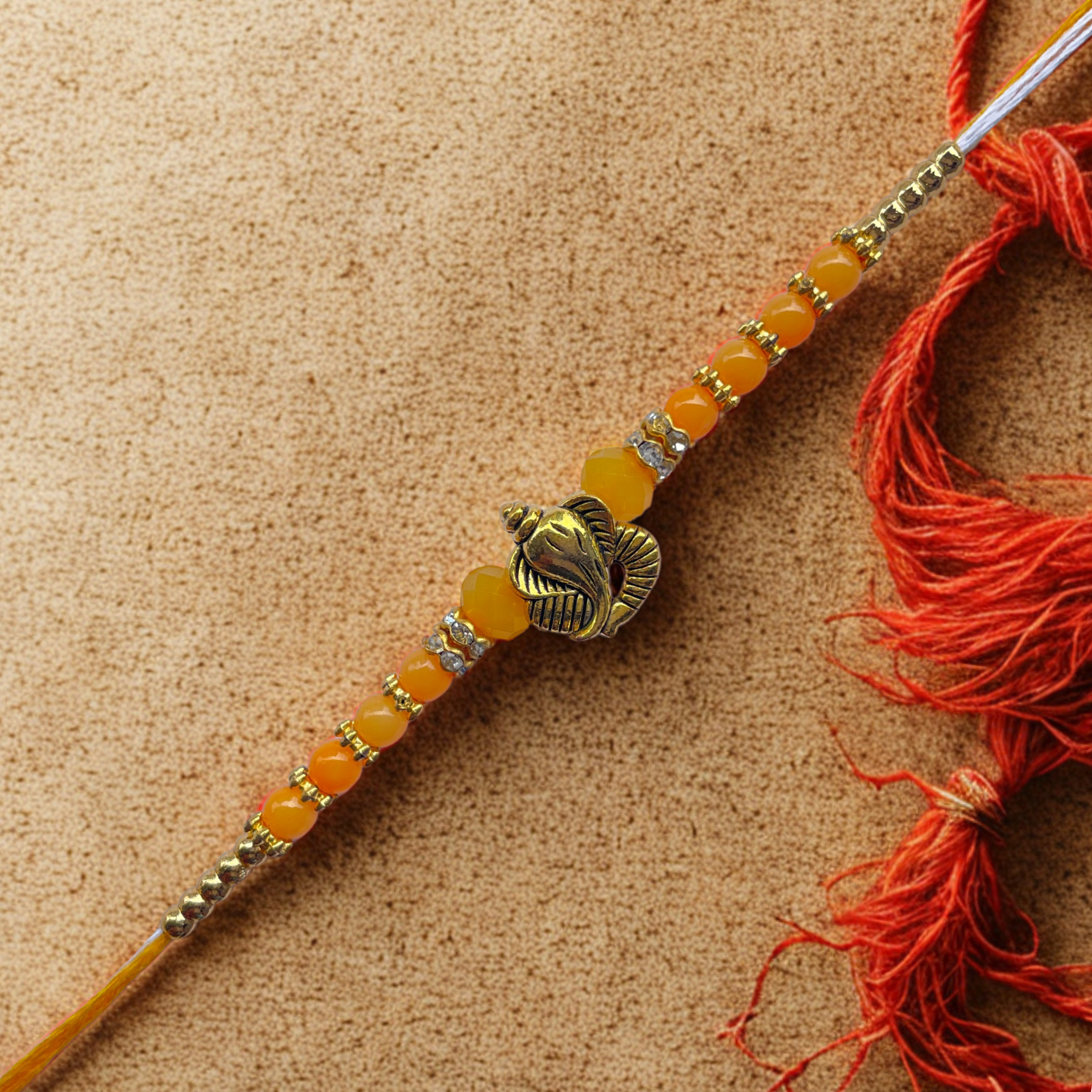Ganesh Motif Rakhi with Yellow Beads & Golden Accents