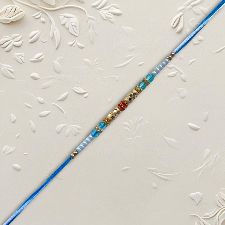 Classic Gold Barrel Bead Rakhi with Light Blue & White Accents