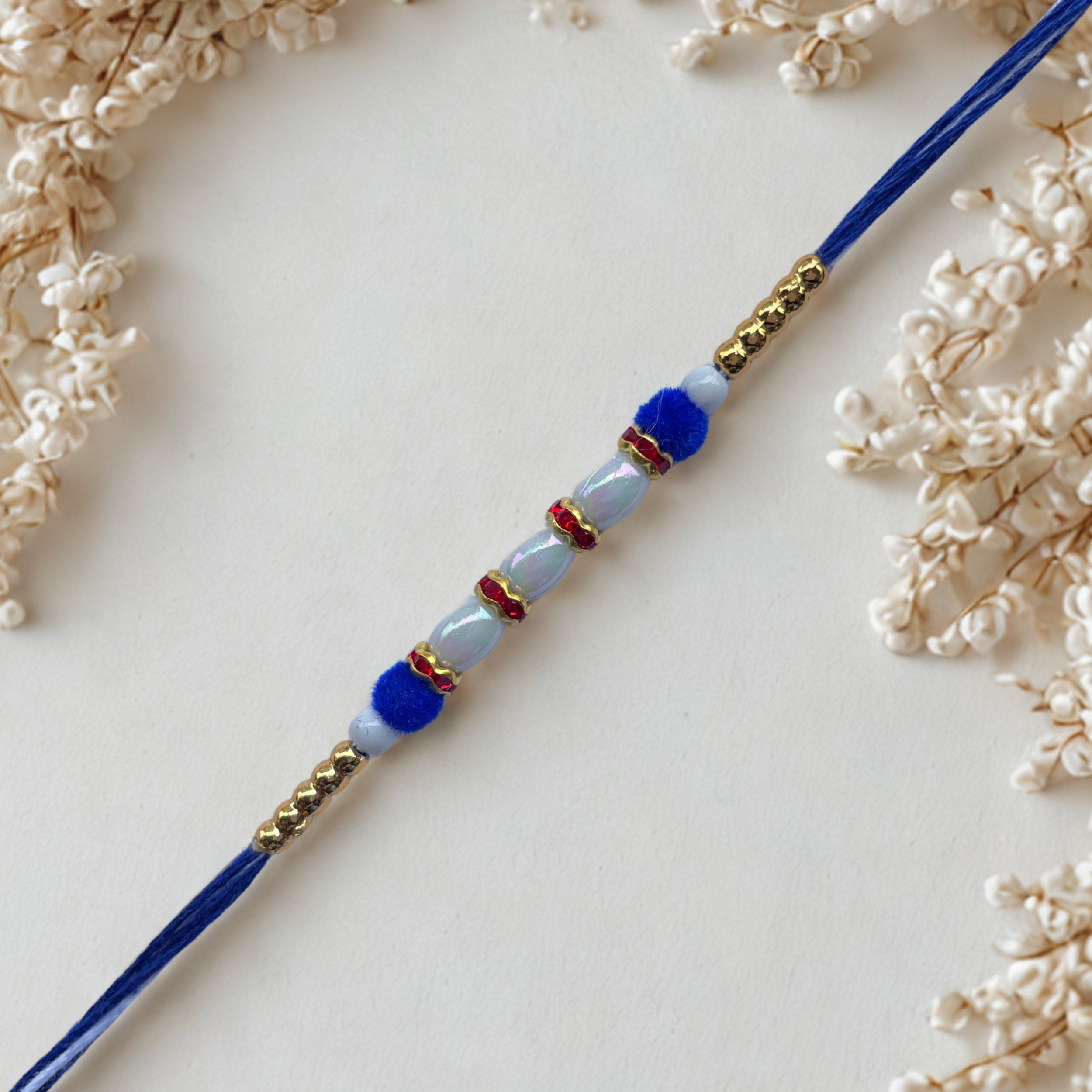 Royal Blue Pearl Rakhi with Golden Bead Accents