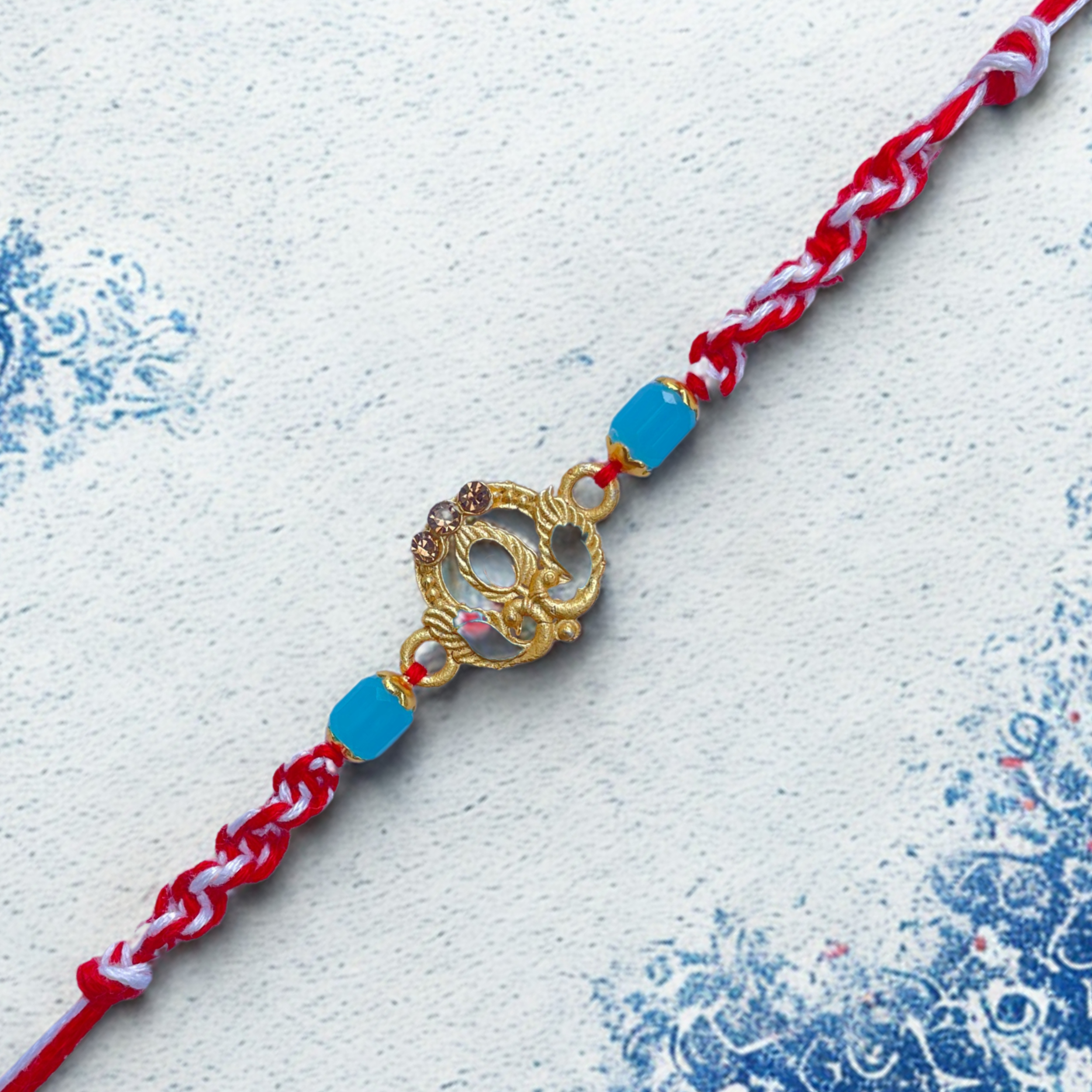 Elegant Peacock Rakhi with Blue Beads & Red Thread