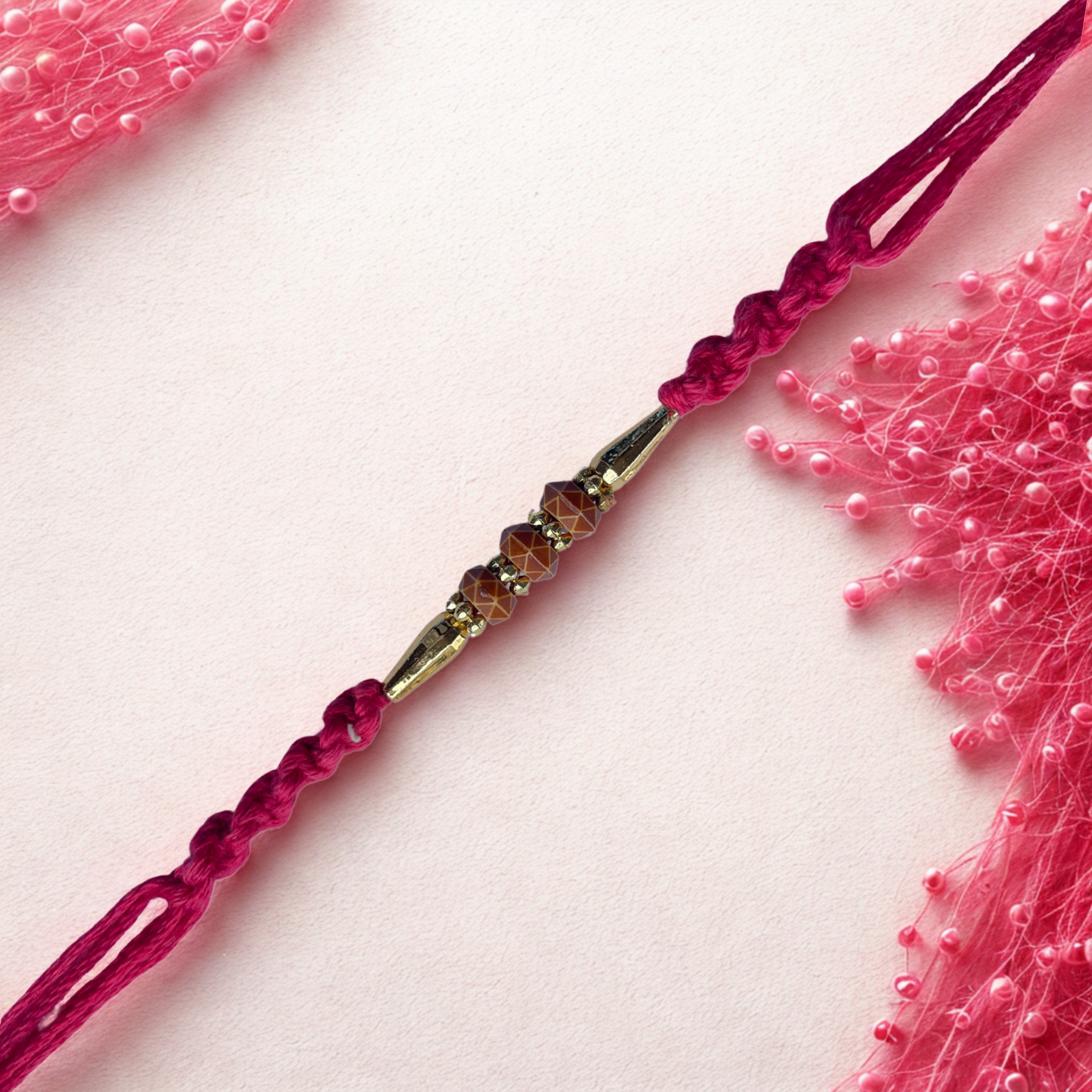 Designer Beaded Rakhi with Golden Accents & Pink Thread
