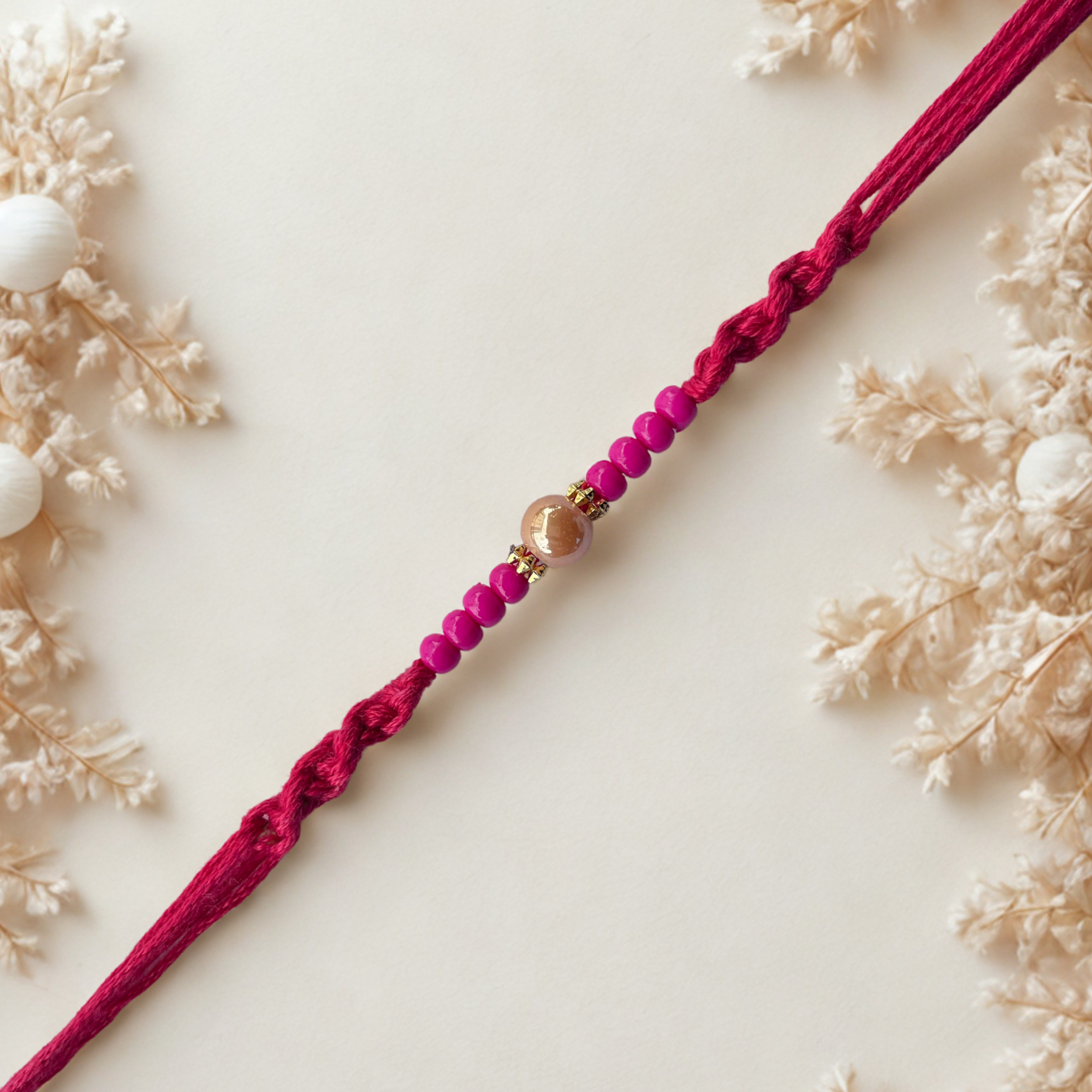 Minimal Pink Beads Rakhi with Golden Accent